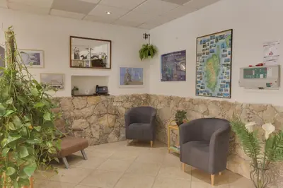 a waiting room with two chairs and a stone wall at Hotel des Etrangers in Bonifacio