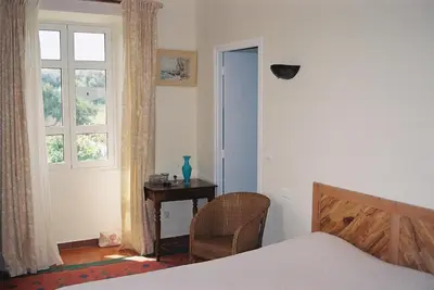 a bedroom with a bed and a table and a window at A Loghja Di Cavallo Morto in Bonifacio