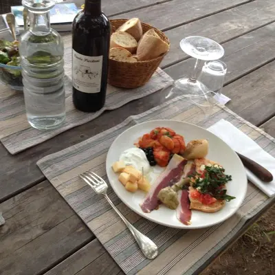 a plate of food on a table with a bottle of wine at A Loghja Di Cavallo Morto in Bonifacio