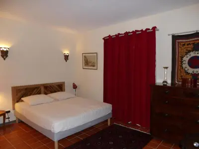 a bedroom with a bed and a red curtain at A Loghja Di Cavallo Morto in Bonifacio