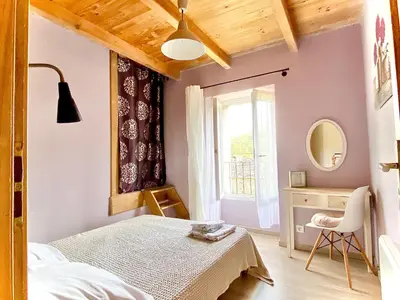 a bedroom with a bed and a desk and a window at Casa Orani in Ponte-Leccia