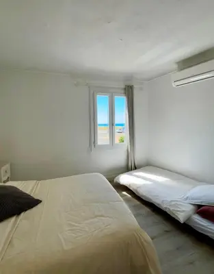 a bedroom with two beds and a window at Magnifique appartement devant la plage in Propriano