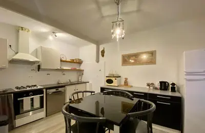 a kitchen with a table and chairs in it at Magnifique appartement devant la plage in Propriano
