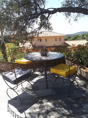 a table and two chairs and a table and a tree at gite tomasini sabrina zirilla in Monacia-dʼAullène