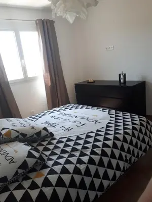 a bedroom with a bed with a black and white comforter at gite tomasini sabrina zirilla in Monacia-dʼAullène
