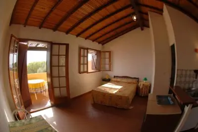 a large living room with a couch and a table at Motel Logis d'Abartello in Olmeto