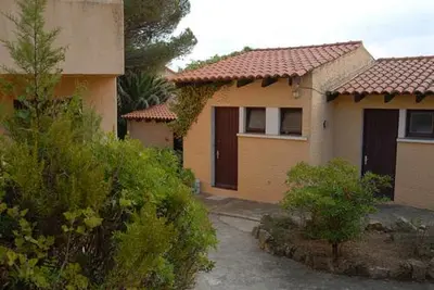 a couple of houses with trees and bushes at Motel Logis d'Abartello in Olmeto