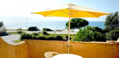 a yellow umbrella sitting on top of a wall at Motel Logis d'Abartello in Olmeto