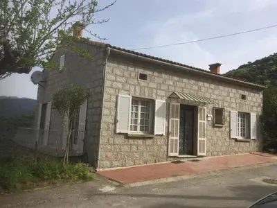 a small brick house with a window and a door at VILLA SANTINE AVEC TERRASSES et VUE PANORAMIQUE meublé tourisme 4 étoiles in Santa-Lucia-di-Tallano