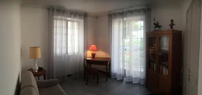 a living room with a couch and a table and windows at VILLA SANTINE AVEC TERRASSES et VUE PANORAMIQUE meublé tourisme 4 étoiles in Santa-Lucia-di-Tallano