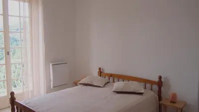 a bedroom with a bed and a large window at VILLA SANTINE AVEC TERRASSES et VUE PANORAMIQUE meublé tourisme 4 étoiles in Santa-Lucia-di-Tallano