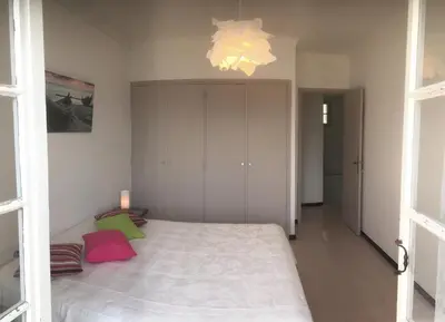 a bedroom with a large bed and a chandelier at VILLA SANTINE AVEC TERRASSES et VUE PANORAMIQUE meublé tourisme 4 étoiles in Santa-Lucia-di-Tallano