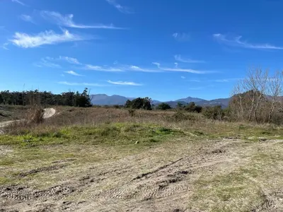 a dirt road in a field with mountains in the background at MAISONS BORD DE MER- MARINE DE SORBO - Gîtes 3 épis in Pinarellu