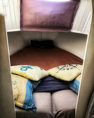 a small closet with two pillows and a mattress at stlocavoile 2, Seuls à bord d un voilier dans le golfe in Porto-Vecchio