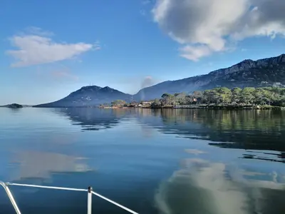a boat on a lake with mountains in the background at stlocavoile 2, Seuls à bord d un voilier dans le golfe in Porto-Vecchio