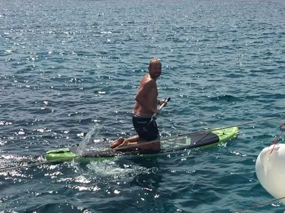 a man sitting on a paddle board in the water at stlocavoile 2, Seuls à bord d un voilier dans le golfe in Porto-Vecchio
