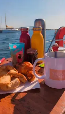 a table with a cup of coffee and pastries on it at stlocavoile 2, Seuls à bord d un voilier dans le golfe in Porto-Vecchio