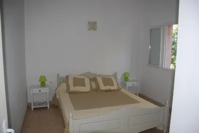a bedroom with a bed with two tables and a window at Residence Ribellinu in Pianottoli-Caldarello