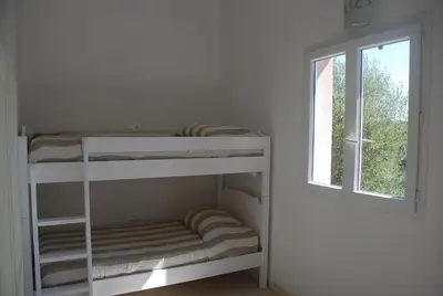 two bunk beds in a room with a window at Residence Ribellinu in Pianottoli-Caldarello