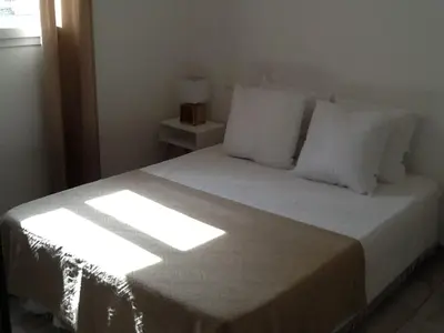 a bedroom with a bed with white sheets and pillows at 10 Casa scaledda 3 étoiles in Porto-Vecchio