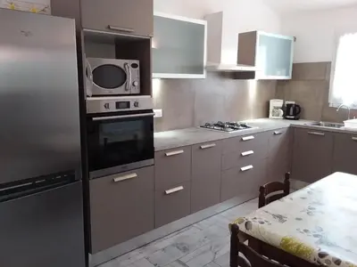 a kitchen with a stainless steel refrigerator and a microwave at 10 Casa scaledda 3 étoiles in Porto-Vecchio
