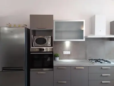 a kitchen with a stainless steel refrigerator and a microwave at 10 Casa scaledda 3 étoiles in Porto-Vecchio