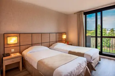 a hotel room with two beds and a window at Chez Walter in Lucciana