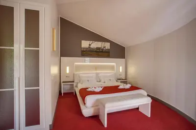 a bedroom with a large bed with a red carpet at Chez Walter in Lucciana