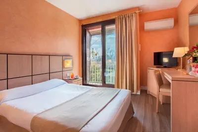 a hotel room with a large bed and a window at Chez Walter in Lucciana