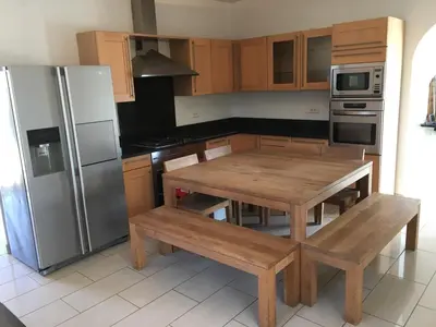 a kitchen with a wooden table and a refrigerator at Villa Torrella in Mezzavia