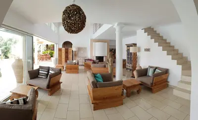 a living room with couches and chairs and a staircase at Villa Torrella in Mezzavia