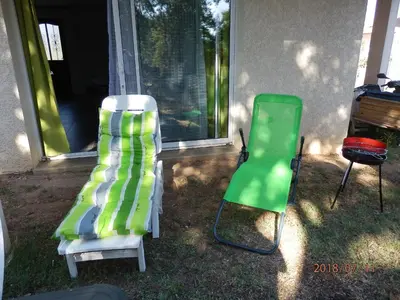 two green and white chairs sitting outside of a house at corse location in Linguizzetta