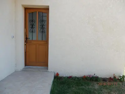 a wooden door of a white house with a porch at corse location in Linguizzetta
