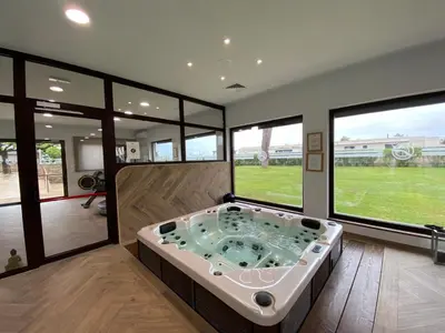 a jacuzzi tub in a room with large windows at Hôtel La Lagune in Lucciana