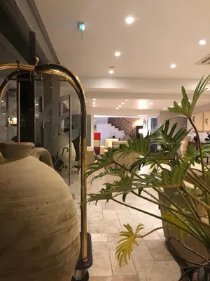 a lobby with plants and a lamp in a room at Hôtel La Lagune in Lucciana