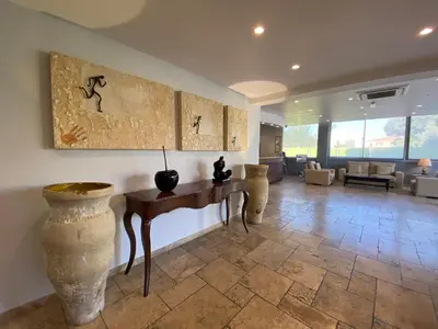 a living room with a table and vases on the wall at Hôtel La Lagune in Lucciana