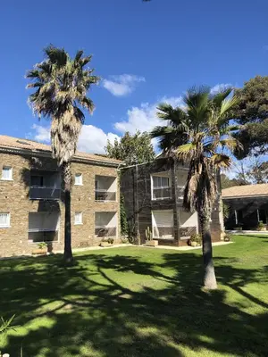 two palm trees in front of a building at Hôtel La Lagune in Lucciana