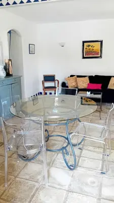 a glass table with two chairs in a living room at soleil et farniente in Cervione