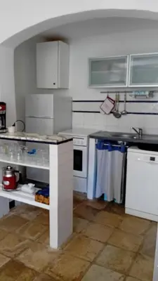 a white kitchen with a sink and a stove at soleil et farniente in Cervione