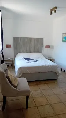 a bedroom with a bed and a chair and a couch at soleil et farniente in Cervione