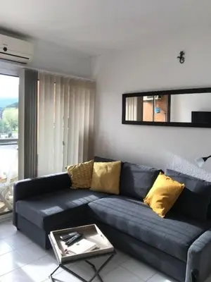 a living room with a blue couch with yellow pillows at Studio Bord De Mer in Santa-Lucia-di-Moriani