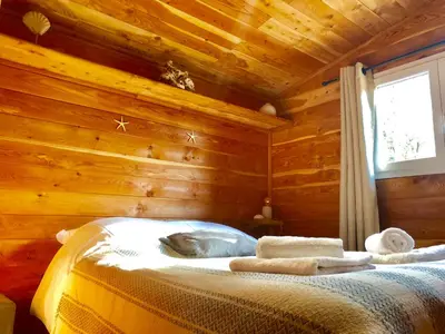 a bedroom with a bed in a log cabin at A Casetta in Pianottoli-Caldarello