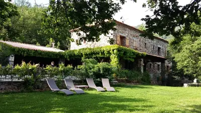 a group of chairs sitting in the grass in front of a building at A Muvrella in Pioggiola