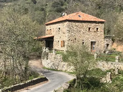 an old stone building with a road in front of it at A Muvrella in Pioggiola