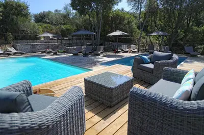 two images of a swimming pool with wicker chairs and a pool at Résidence Sophia in Bonifacio