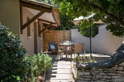 a patio with a table and chairs under an umbrella at Résidence Sophia in Bonifacio