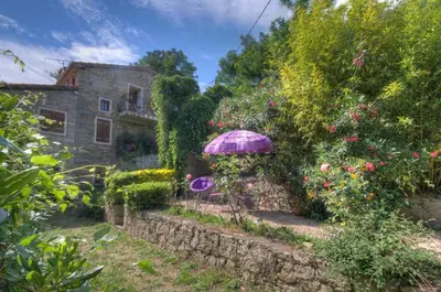 a garden with an umbrella in front of a building at A Pivarella in Grosseto-Prugna