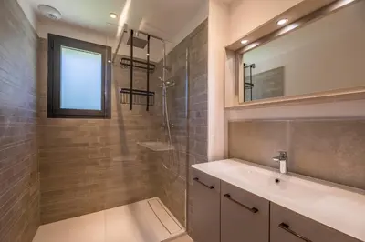 a bathroom with a sink and a shower with a mirror at Villa 18 in Porto-Vecchio