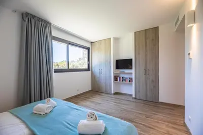 a bedroom with a blue bed with towels on it at Villa 18 in Porto-Vecchio