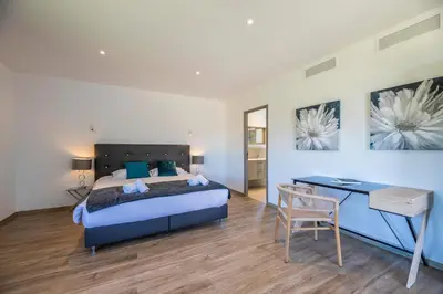 a bedroom with a bed and a desk in it at Villa 18 in Porto-Vecchio